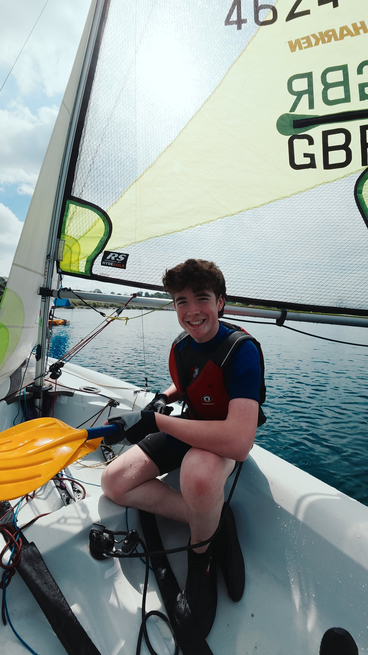 A sailor handling the ropes inside a dinghy